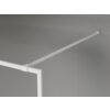 Biała ścianka prysznicowa z ramką i wspornikiem zamontowana na szarej ścianie. Produkt ma minimalistyczny design i matowe wykończenie.