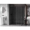 Nowoczesna łazienka z ciemną ścianką prysznicową typu walk-in, wykończoną w kolorze gun metal, na tle ciemnych płytek ułożonych w jodełkę. Obok znajduje się wolnostojąca umywalka z okrągłym lustrem oraz wanna z ręcznikiem na wieszaku.