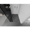 Czarno-biała fotografia przedstawia nowoczesną łazienkę z prysznicem typu walk-in, wyposażonym w czarną ściankę prysznicową oraz chromowane elementy. Na podłodze widoczna jest szara płytka, a na ścianie zamontowany jest panel prysznicowy z wężem.