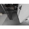 Na zdjęciu znajduje się nowoczesna łazienka z szklaną ścianką prysznicową typu walk-in, wykończoną w kolorze gun metal. W tle widoczna jest umywalka z lustrem oraz półki z akcesoriami łazienkowymi.