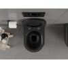 Czarne, matowe WC typu rimless z deską wolnoopadającą, zamontowane na szarej ścianie, obok uchwytu z papierem toaletowym i półki z kosmetykami. Nad WC znajduje się czarny panel spłukujący z dwoma przyciskami.