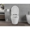 Na zdjęciu znajduje się biała, połyskująca miska WC typu Rimless z deską wolnoopadającą slim, zamontowana na tle szarej ściany z płytek. Obok miski znajduje się uchwyt z papierem toaletowym oraz szczotka toaletowa w metalowym stojaku.
