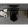 Czarna matowa miska WC z deską wolnoopadającą, zamontowana na ścianie z szarymi płytkami, obok której znajduje się uchwyt z papierem toaletowym oraz półka z książkami. Na ścianie widoczny jest przycisk spłukujący, a na książce napis "JOHN RUSKIN VON VENEDIG".