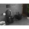 Czarne, matowe WC typu rimless oraz bidet zamontowane na ścianie w nowoczesnej łazience z szarymi, teksturowanymi płytkami. Obok WC znajduje się uchwyt z papierem toaletowym, a na podłodze leżą książki i czasopisma.