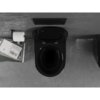 Czarne, błyszczące WC typu Rimless z deską wolnoopadającą, zamontowane na szarej ścianie, obok którego znajduje się uchwyt z papierem toaletowym oraz stos książek. Na jednej z książek widoczny jest napis "John Ruskin VON VENDIG".