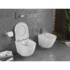 Na zdjęciu znajduje się biała, połyskująca miska WC z otwartą deską oraz bidet, zamontowane na tle szarej, teksturowanej ściany. Obok miski WC wisi uchwyt z rolką papieru toaletowego, a na podłodze leżą książki i czasopisma.