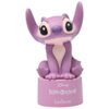 Fioletowa figurka przedstawiająca postać z dużymi uszami, siedząca na podstawce z napisem "Disney Lilo & Stitch" oraz "LEXIBOOK". Figurka ma duże, czarne oczy i jasny wzór na brzuchu.