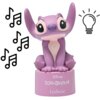 Fioletowa figurka przedstawiająca postać z dużymi uszami, siedząca na podstawce z napisem "Disney Lilo & Stitch" oraz "LEXIBOOK". Obok figurki znajdują się ikony nutek i żarówki.