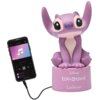 Fioletowa lampka nocna w kształcie postaci z bajki, siedząca na podstawce z napisami "Disney Lilo & Stitch" oraz "Lexibook", obok której znajduje się smartfon z odtwarzaczem muzyki. Smartfon jest podłączony do lampki za pomocą kabla.