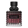 Kwadratowy flakon perfum o fakturze przypominającej diamenty, z czarnym korkiem i etykietą z napisem "VALENTINO" w różowym kolorze. Flakon ma ciemnoróżowy odcień w górnej części, przechodzący w przezroczysty na dole.