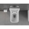 Biała, połyskująca miska WC typu rimless jest zamontowana na ścianie wyłożonej ciemnymi płytkami, obok znajduje się uchwyt z rolką papieru toaletowego. Podłoga jest pokryta szarymi płytkami o delikatnym wzorze.