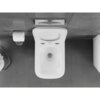 Biała, połyskująca miska WC typu Rimless Tornado z deską wolnoopadającą slim, wykonana z duroplastu, zamontowana na tle szarych płytek. Obok znajduje się uchwyt z rolką papieru toaletowego oraz przycisk spłukujący.