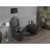 Na zdjęciu znajduje się czarna matowa miska WC typu rimless z deską wolnoopadającą oraz bidet, oba zamontowane na ścianie wyłożonej szarymi płytkami. Obok miski WC widoczny jest uchwyt z papierem toaletowym, szczotka toaletowa oraz panel spłukujący z dwoma okrągłymi przyciskami.