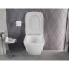 Na zdjęciu znajduje się biała, połyskująca miska WC bez kołnierza, zamontowana na tle ściany z geometrycznym wzorem. Obok znajduje się uchwyt z rolką papieru toaletowego oraz stolik z otwartą gazetą.