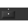 Czarna matowa umywalka wpuszczana w blat o prostokątnym kształcie z otworem na baterię i odpływ, umieszczona na szerokim panelu. Na powierzchni widoczne jest subtelne logo "Mexen".