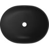 Czarna, matowa umywalka nablatowa o owalnym kształcie z centralnym otworem odpływowym. Na górnej krawędzi widoczny jest napis "MEXEN".