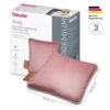 Na zdjęciu znajduje się różowa poduszka elektryczna z brązowym uchwytem, obok której widoczne jest opakowanie z napisem "beurer Heaty BATTERY-OPERATED HEATING PAD AKKU-HEIZKISSEN". Na opakowaniu znajdują się również informacje o funkcjach produktu oraz logo "German Engineering" z gwarancją na 3 lata.