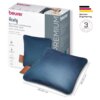 Na zdjęciu znajduje się elektryczna poduszka w kolorze niebieskim oraz jej opakowanie z widocznymi napisami: "beurer", "Heaty", "BATTERY-OPERATED HEATING PAD", "AKKU-HEIZKISSEN", "Cozy warmth - cordless", "Kuschlige Wärme - kabellos", a także logo "German Engineering" i informacja o 3-letniej gwarancji. Poduszka ma wymiary 45,00 cm x 45,00 cm.