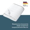 Biały koc elektryczny z widocznym pilotem leży na tle w dwóch odcieniach, z logo "German Engineering" w prawym górnym rogu. Na dole znajduje się tekst: "Bezpieczne stosowanie dzięki systemowi bezpieczeństwa Beurer".