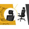 Czarno-szary fotel biurowy z siatki i tkaniny, z regulowanym zagłówkiem i podłokietnikami, na kółkach, przedstawiony na tle żółtego wzoru z okręgiem. W tle widoczna jest osoba siedząca na krześle, uśmiechnięta, w pasiastym stroju.