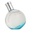 Przezroczysta butelka perfum o kulistym kształcie z metalowym korkiem, wypełniona niebieskim płynem. Na butelce widoczny jest tekst: "EAU DES MERVEILLES BLEUE" oraz "HERMÈS PARIS".