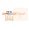Flakon perfum z przezroczystego szkła z metalowym korkiem i pomarańczową wstążką, obok znajduje się pudełko z napisem "Chloé Eau de Toilette Rose Tangerine 1.6 FL OZ (50 ml)". Na flakonie widoczne jest logo "Chloé".