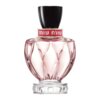Szklany flakon perfum o różowym odcieniu z czarnym korkiem, ozdobiony złotym pierścieniem z napisem "miu miu". Flakon ma elegancki, rzeźbiony wzór i stoi na przezroczystej podstawie.