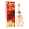 Na zdjęciu widoczna jest butelka perfum oraz pudełko z napisem "Miami Glow by JLO". Pudełko ma ciepłe, pomarańczowo-czerwone tło z motywem palmy, a butelka jest ozdobiona kolorową bransoletką z zawieszką w kształcie klapek.