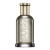 Butelka perfum o metalicznym wykończeniu z widocznym napisem "BOSS HUGO BOSS" wytłoczonym na powierzchni. Kształt butelki jest cylindryczny z zaokrąglonymi krawędziami i złotym korkiem.
