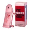 Różowy flakon perfum w kształcie deskorolki z napisem "212" stoi obok pudełka z tekstem "212 Heroes Forever Young". Na pudełku widnieje również napis "Carolina Herrera" oraz informacje o pojemności 50 ml i rodzaju produktu jako "eau de parfum for her natural spray".
