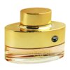 Złoty flakon perfum o zaokrąglonym kształcie z widocznym napisem "VANITY FEMME Essence" oraz "EAU DE PARFUM FOR HER". Na górnej części flakonu znajduje się okrągłe logo z literą "S".