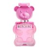 Różowa butelka perfum w kształcie misia z napisem "MOSCHINO" na przodzie. Kształt misia jest szczegółowo odwzorowany, z widocznymi uszami, oczami i nosem.