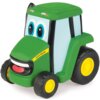 Zabawka w kształcie zielonego traktora z dużymi oczami i uśmiechem, z żółtym napisem "John Deere" na boku. Traktor ma czarne koła z żółtymi felgami.