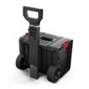 Czarna mobilna skrzynia QBRICK System PRO Cart 2.0 z dużymi kołami i teleskopowym uchwytem, posiada czerwone zapięcia i widoczne logo "QBRICK" na boku. Skrzynia ma solidną konstrukcję z wyraźnymi liniami i uchwytem na górze.