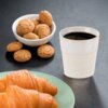 Na zdjęciu znajduje się kubek z ciemnym napojem, obok którego stoi miseczka z ciasteczkami oraz talerz z dwoma rogalikami. Kubek jest wykonany z kamionki i ma pojemność 80 ml.