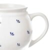 Biały ceramiczny kubek o pojemności 190 ml z niebieskimi, drobnymi wzorami przypominającymi kwiaty. Kubek ma zaokrąglony kształt i duże ucho.