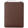 Ciemnobrązowe etui na laptopa wykonane z gładkiego materiału, z widocznymi zaokrąglonymi rogami i delikatnym przeszyciem wzdłuż krawędzi. W górnej części etui wystaje fragment białego laptopa z widocznymi czarnymi elementami.