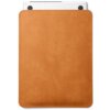 Jasnobrązowe etui na laptopa wykonane z gładkiego materiału, z widocznymi zaokrąglonymi rogami i przeszyciami wzdłuż krawędzi. W górnej części wystaje fragment białego laptopa z dwoma czarnymi elementami.