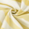Zdjęcie przedstawia materiał w żółto-białe pasy, ułożony w spiralny wzór. Tkanina ma gładką fakturę i jest sfotografowana z bliska, co podkreśla jej wzór i strukturę.