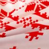 Zdjęcie przedstawia fragment pościeli z czerwonym, geometrycznym wzorem na jasnym tle. Wzór składa się z symetrycznych, pikselowych kształtów, które tworzą powtarzający się motyw.