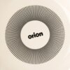 Na zdjęciu widoczny jest kremowy garnek emaliowany z czarnym wzorem w postaci promieniście rozchodzących się linii, z napisem "orion" pośrodku. Wzór znajduje się na jasnym tle.