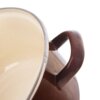 Brązowy garnek emaliowany z uchwytem, widoczny z boku, z jasnym wnętrzem i przezroczystą pokrywką. Produkt to "Garnek emaliowany BROWN 16 cm, 1,4 l".