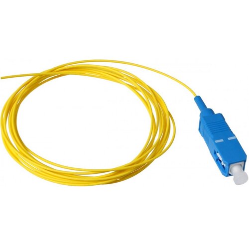 Na zdjęciu znajduje się żółty kabel światłowodowy z niebieską wtyczką SC/UPC. Kabel jest zwinięty w luźną pętlę, a wtyczka ma prostokątny kształt z białą końcówką.