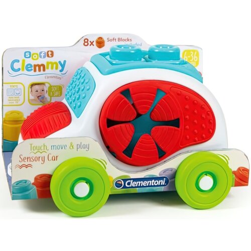 Na zdjęciu znajduje się zabawkowe autko sensoryczne z dużymi, kolorowymi kołami i klockami na górze, w opakowaniu z napisem "soft Clemmy Clementoni" oraz "Touch, move & play Sensory Car". Widoczne jest również logo "Clementoni" oraz informacja o 8 miękkich klockach w zestawie.