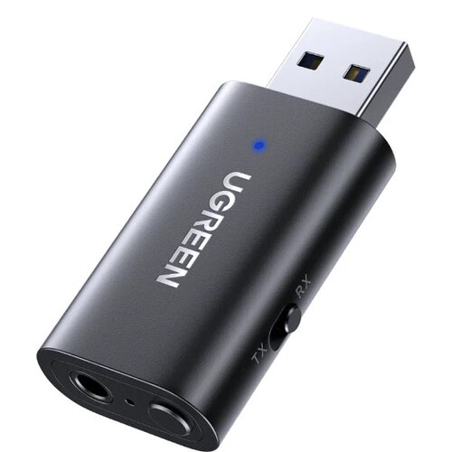 Na zdjęciu znajduje się czarny adapter Bluetooth z wtykiem USB, na którym widnieje napis "UGREEN" oraz niebieska dioda. Adapter posiada dwa gniazda audio oraz przełącznik oznaczony jako "TX" i "RX".