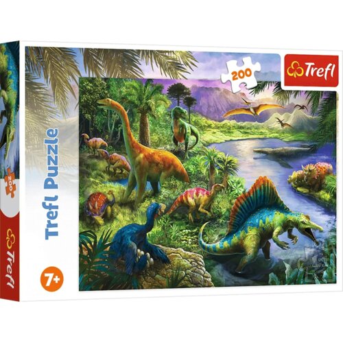 Opakowanie puzzli przedstawia kolorową ilustrację z różnymi dinozaurami w bujnym, tropikalnym krajobrazie z rzeką i górami w tle. Na opakowaniu widnieje napis "Trefl Puzzle", liczba elementów "200" oraz oznaczenie wiekowe "7+", a w rogu znajduje się logo 