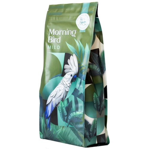 Opakowanie kawy ziarnistej z napisem "Morning Bird Mild" oraz ilustracją białego ptaka na tle zielonych liści. W górnej części widoczna jest okrągła pieczęć z rysunkiem filiżanki.