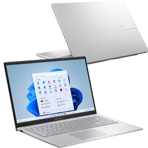 Na zdjęciu widoczny jest srebrny laptop z otwartym ekranem, na którym wyświetlony jest pulpit systemu Windows 11 z menu Start. Na obudowie laptopa znajduje się logo "ASUS VivoBook".