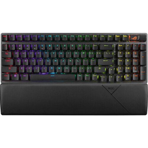Czarna klawiatura mechaniczna z podświetleniem RGB, posiadająca pełny układ klawiszy oraz dodatkowe przyciski numeryczne po prawej stronie. Na klawiaturze widoczne jest logo "ROG" w prawym górnym rogu oraz na podkładce pod nadgarstki.