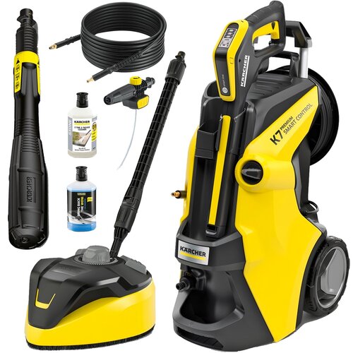 Na zdjęciu znajduje się żółto-czarna myjka ciśnieniowa z napisem "KARCHER K7 Premium Smart Control" oraz różne akcesoria, w tym węże, dysze i butelki z detergentami. Widoczne są również logo "KARCHER" oraz etykiety na butelkach.